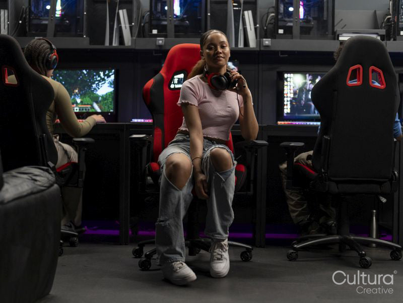 Young gamer looking at camera while friends playing video games