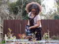 Girl watering plants in backyard