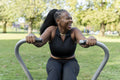 Smiling young woman exercising in outdoor gym