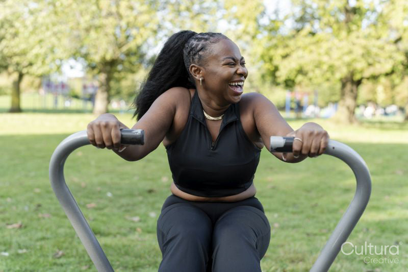 Smiling young woman exercising in outdoor gym