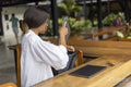 Woman sitting in hotel lounge, removing mobile devices from bag