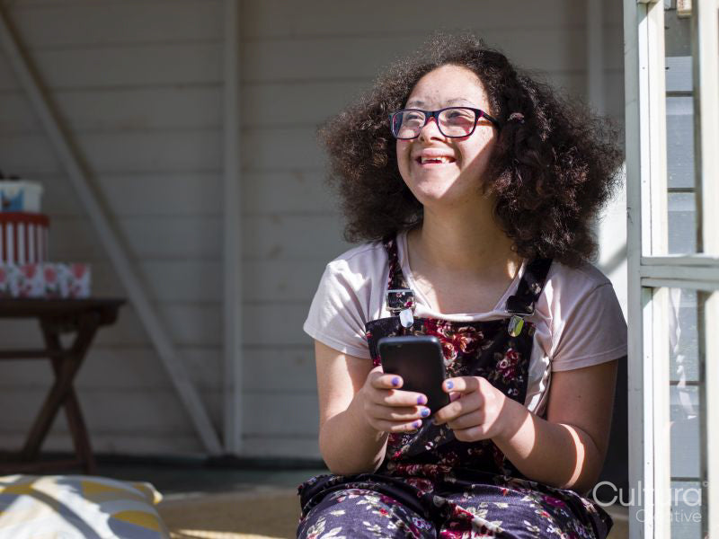 Girl with smartphone sitting on porch