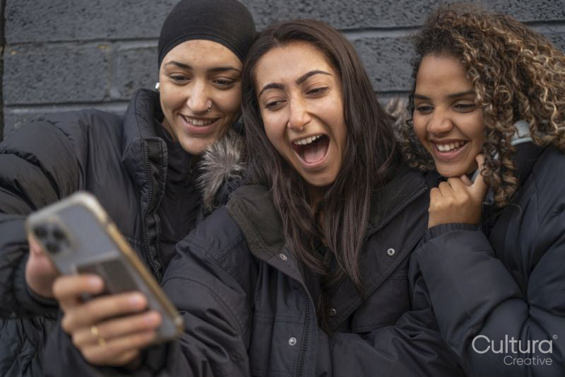 Three young women looking at smartphone