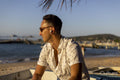 Man wearing earbuds sitting at beach