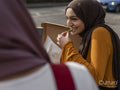 Smiling woman eating pizza in park with friend