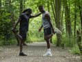 Two men stretching in forest