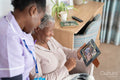 Smiling caregiver and senior woman looking at photography