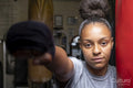 Young woman training on boxing bag, portrait