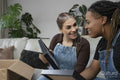 Two young women unpacking boxes in new home