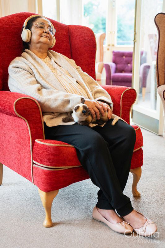Senior woman sitting in armchair and relaxing at nursing home