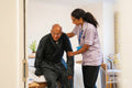 Nurse helping senior man in his room at nursing home