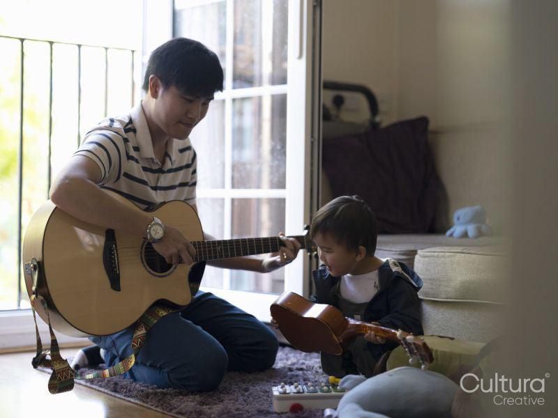 Father and baby son playing guitar and ukulele