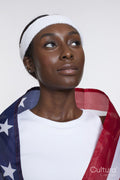Studio portrait of athletic woman wrapped in American flag