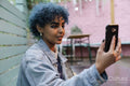 Young woman with blue hair using phone