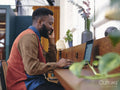 Smiling businessman using smart phone and laptop