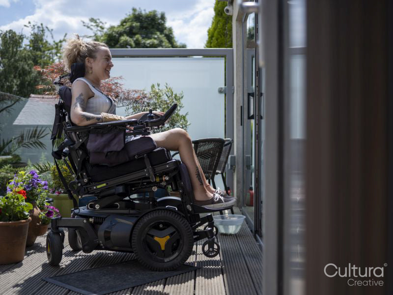 Woman in electric wheelchair relaxing on deck