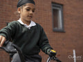 Boy in school uniform riding bicycle