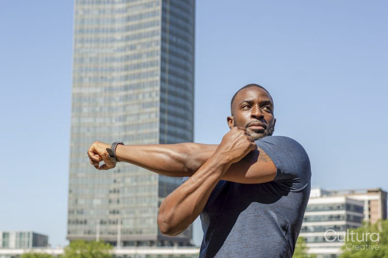 Mid adult man stretching in urban setting