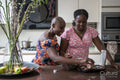 Smiling mother and teenage daughter baking muffins in kitchen