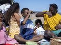 Boy looking through binoculars on beach