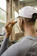 Woman putting on in-ear headphones at gym