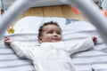 Baby girl lying on play mat at home