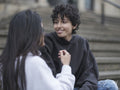 Smiling female couple sitting on stairs in city