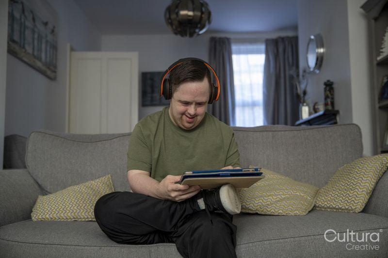Man sitting on sofa and using digital tablet