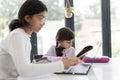 Little girl doing homework with sister