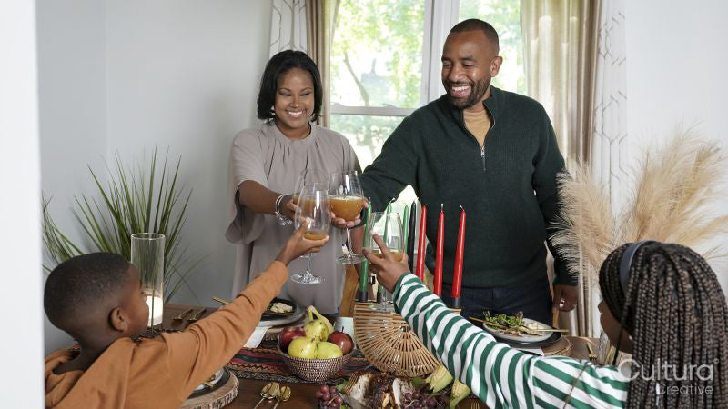Family with children raising toast during Kwanzaa meal