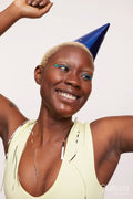 Smiling woman with short white hair, wearing blue party hat