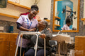 Nurse helping woman with mobility walker in hair salon
