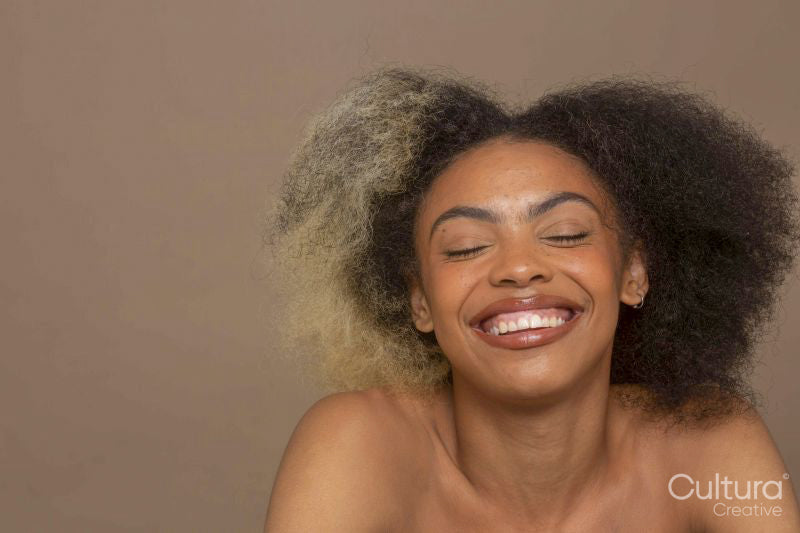 Studio portrait of smiling woman with two toned hair