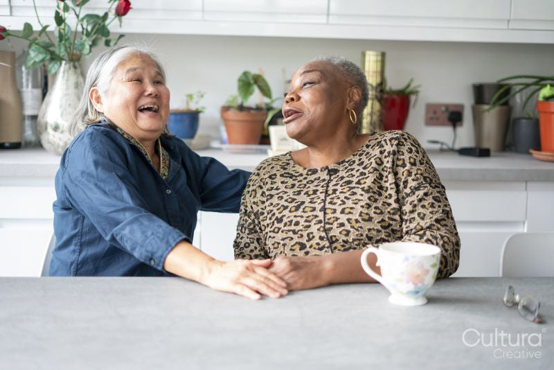 Two senior women sitting at kitchen table