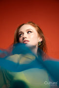 Woman in yellow dress veiled by flowing blue fabric