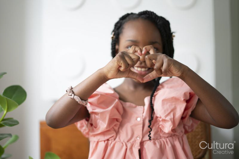 Smiling girl showing heart sign