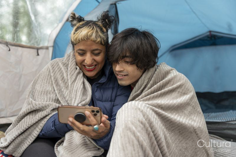 Mother and son using phone in tent