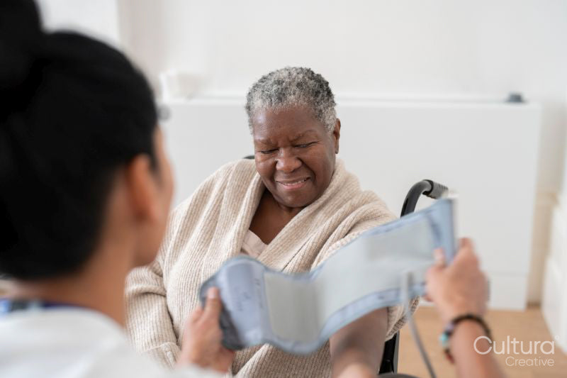 Female doctor measuring senior patients blood pressure