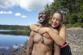 Smiling couple embracing on rocky lakeshore, Yorkshire, UK