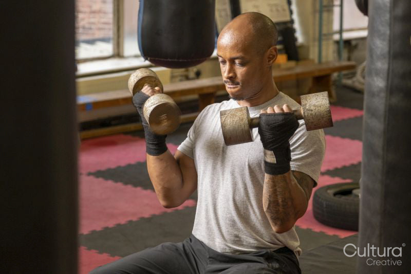 Mature man lifting dumbbells in gym