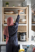 Woman in hijab putting dishes on shelf