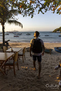 Rear view of man with backpack on beach