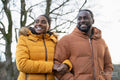 Couple in winter jackets walking in rural setting