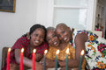 Teenage girl with mother and grandmother at table with Kwanzaa candles