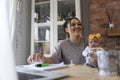 Smiling mother holding baby girl while studying at home