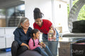 Two sisters and grandmother playing at table in living room