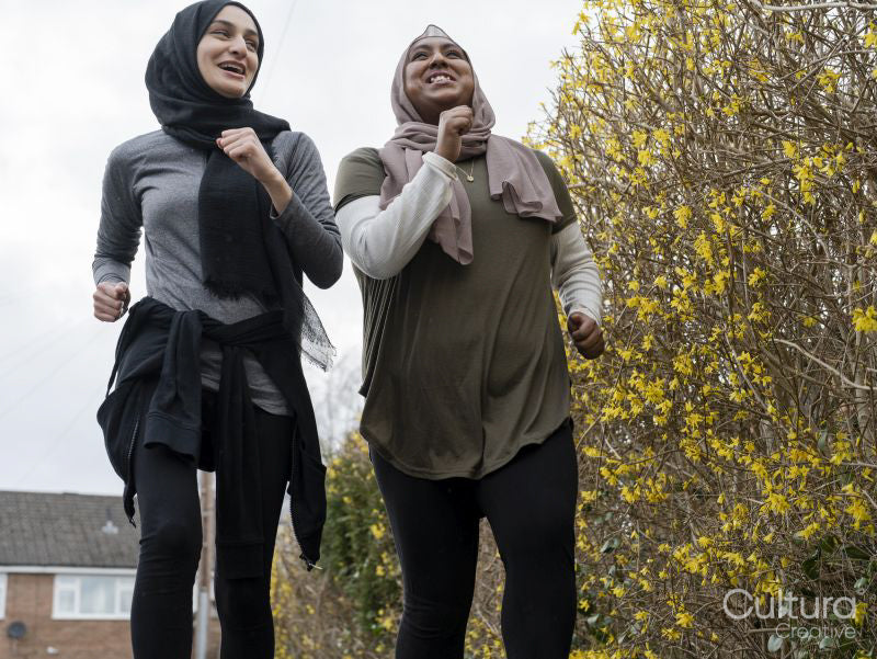 Smiling women jogging together