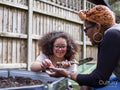 Mother and daughter gardening in backyard