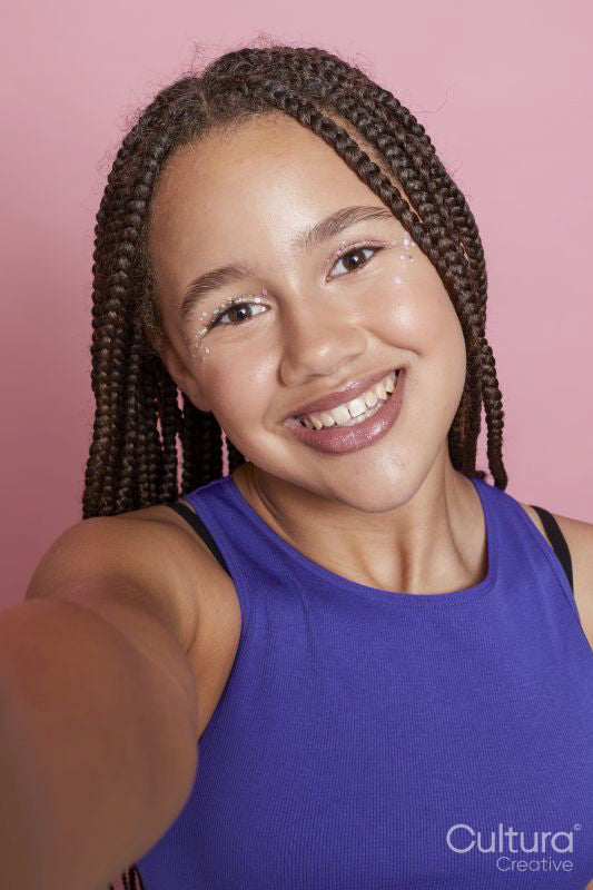 Portrait of smiling girl with braids and decorative stickers on face