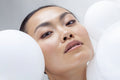 Close-up of woman with white balloons
